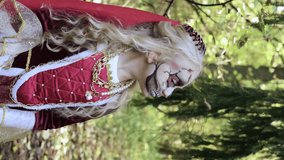 Girl child in a medieval dress demonstrates Halloween makeup on her face. Vertical video