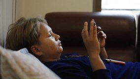 Thai woman with short hair watching a video on her mobile phone