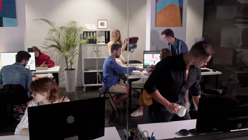 Wide Angle View Of Busy Design Office With Workers At Desks. Team job. Young businessmans crew working with new startup project in modern loft. Design Team Planning for a New Project. Team of young Royalty-Free Stock Footage #1106574371