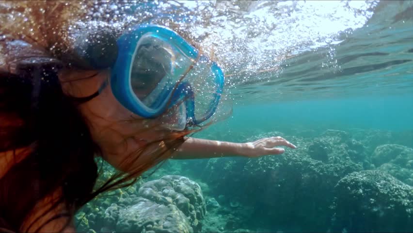 Underwater of a woman snorkeling above a coral reef. Girl in snorkeling mask dive underwater with tropical fishes in coral reef sea pool. Travel lifestyle, water sport outdoor adventure, swimming | Shutterstock HD Video #1106574429