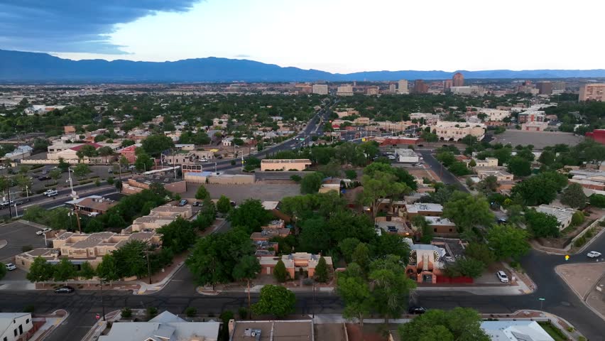 Residential neighborhood outside of Albuquerque, New Mexico. Bright sunset over mountains in distance. Adobe housing development.