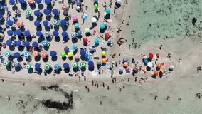 Aerial view on beach, people and umbrellas. Vacation and adventure. Europe, Mediterranean Sea. Top view from drone at beach and azure sea. View on the coast from drone. 