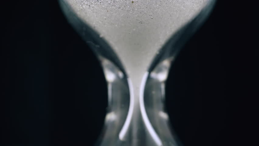 CU, macro view shot: glowing clean fine sand pours down inside traditional hourglass to measure life duration on black background extreme closeup Royalty-Free Stock Footage #1106586107