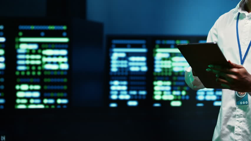 IT specialist walking through server rows performing data backups, close up. Serviceman using tablet to make sure electric generators are able to ensure operational continuity Royalty-Free Stock Footage #1106589275