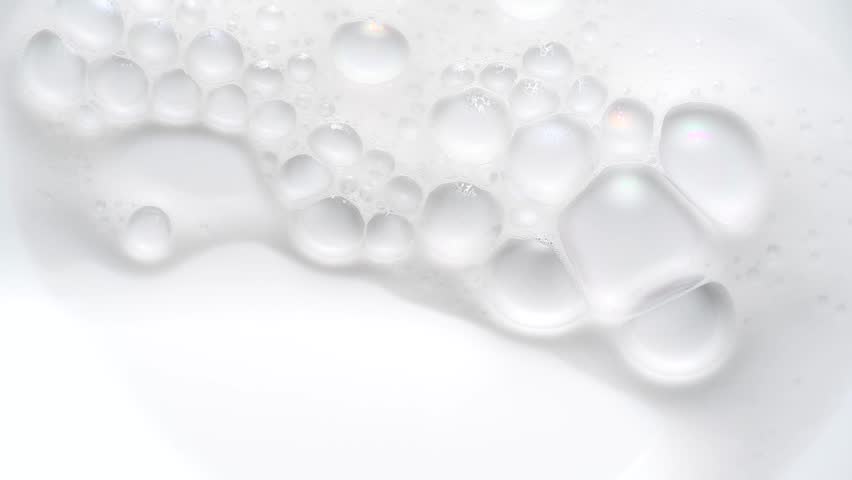 Foam bubbles background. Moving Soap foam popping bubble, white backdrop. Soap sud macro structure. Soap foam close-up. Clean, cleaning concept, laundry, shower. Slow motion.  Royalty-Free Stock Footage #1106590955