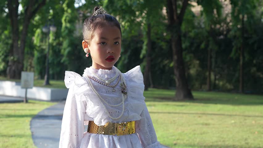 Little Thai Girl in Traditional Thai Dress at park.