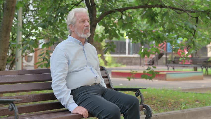 Senior Old Man Sitting Outdoor with Back Pain