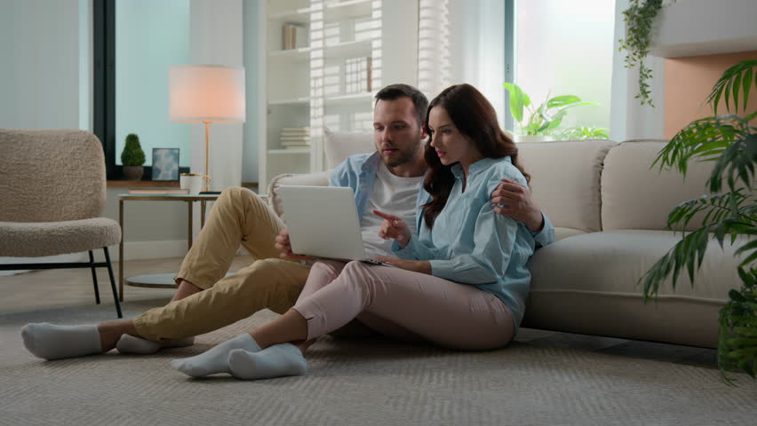 Excited happy young family win with laptop at home floor achievement online victory couple man woman husband wife winning with computer internet achieve kissing celebrating applauding betting success Royalty-Free Stock Footage #1106596741