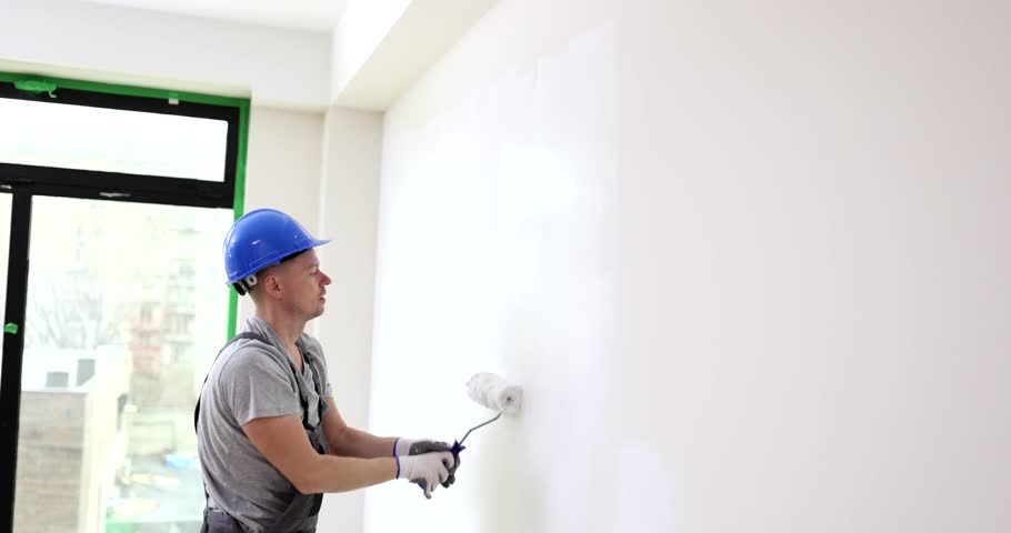 Painter painting wall with paint roller