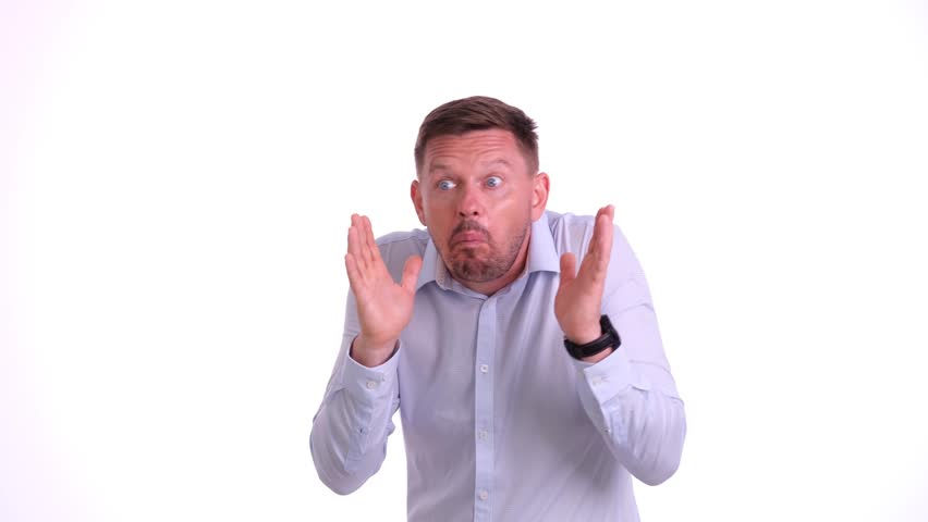 Young secret man looks to side, says quieter be quiet and pressing finger to lips shhh