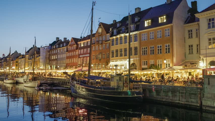Copenhagen, Denmark. Panning evening shot of Nyhavn canal New Harbour with colorful houses and sailing boats in Copenhagen. 4K HDR shot Royalty-Free Stock Footage #1106599439
