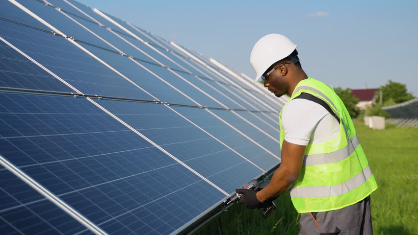 African American engineer maintaining solar panels. Technician working outdoor on ecological solar farm construction. Renewable clean energy technology concept Royalty-Free Stock Footage #1106602009