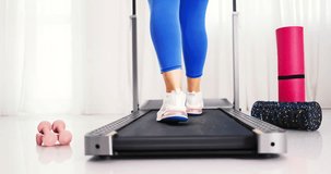Sporty woman training on walking treadmill at home or in gym, concept for exercising, fitness, yoga, pilates