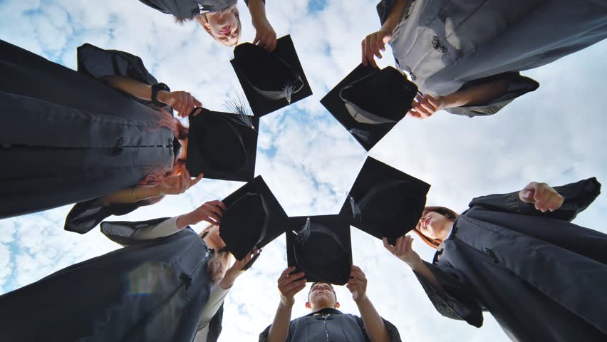 Joyful graduates stand in a circle and toss their caps up. Royalty-Free Stock Footage #1106602517
