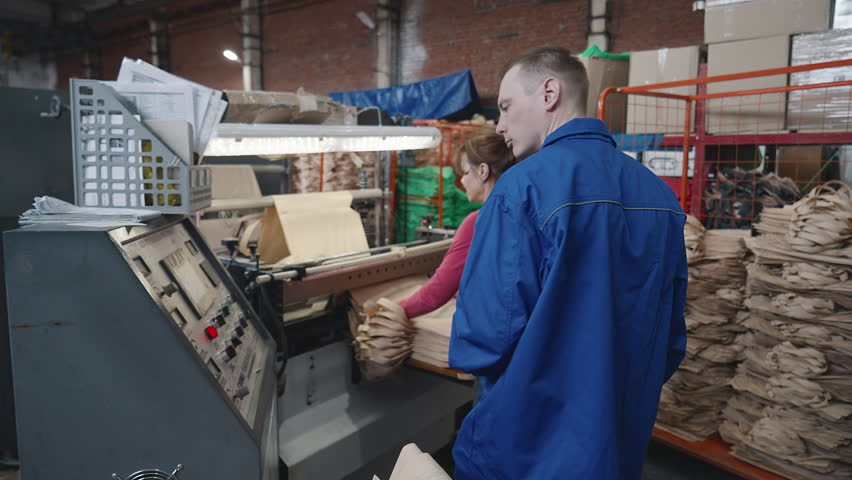 Collecting the shopping bags from the production line. Checking the production quality of the shopping bags coming from the conveyor line. Storing the shopping bags exiting the production line. Royalty-Free Stock Footage #1106609149