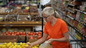 Slow motion portrait of smiling happy pretty mature woman selecting lemons in a grocery store. - Powered by Shutterstock - Get 15% off with code: PIKWIZARD15