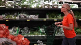 Profile side view of pretty mature blonde woman pushing shopping cart through a grocery store. - Powered by Shutterstock - Get 15% off with code: PIKWIZARD15