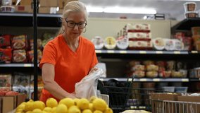 Slow motion portrait of smiling happy pretty mature woman selecting lemons in a grocery store. - Powered by Shutterstock - Get 15% off with code: PIKWIZARD15