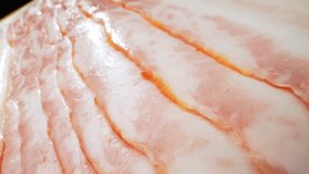 Macro video showcases raw bacon in intricate detail using a probe lens. Captivating textures, marbling, and rich colors of the bacon invite a sensory experience that tantalizes the taste buds. 

