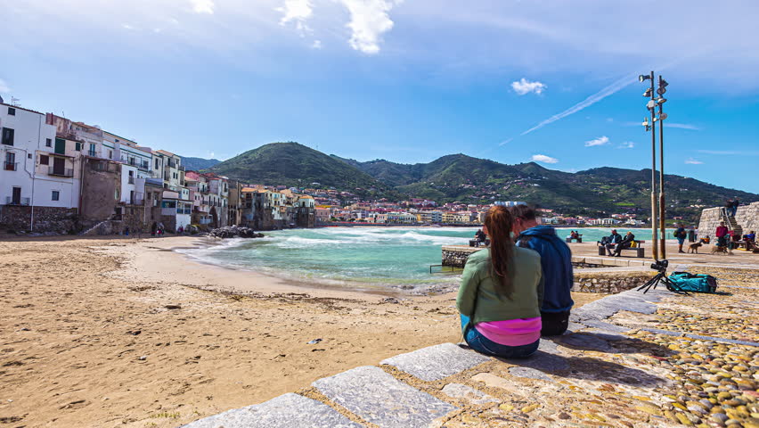 Timelapse of a Couple watching Moving Clouds and ocean waves at a coastal beach of Sicily in Italy