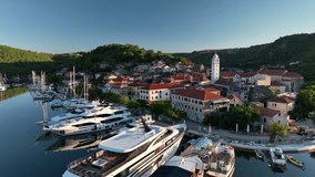 Aerial drone video slowly flying backwards and away from the old town of Skradin in Croatia, revealing the surrounding landscape.