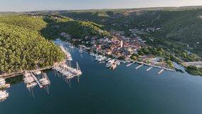 Aerial drone video flying towards the old town of Skradin in Croatia from far away, slowly descending