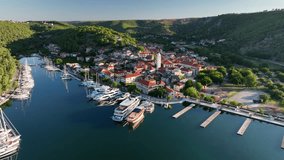 Aerial drone video slowly flying to the left and rotating around the old town of Skradin in Croatia as birds fly, near Krka National Park
