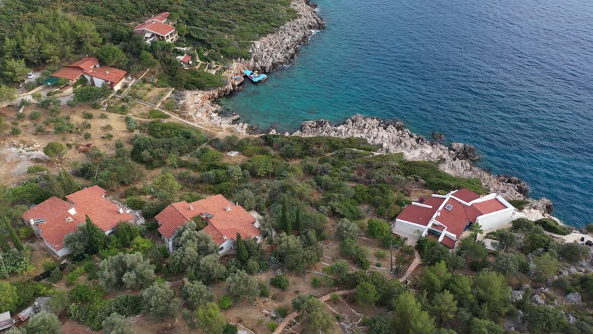 Boutique hotels with private beaches located on the azure shores of Kas resort. Hillside houses and hotels overlooking the Mediterranean Sea in Turkey

