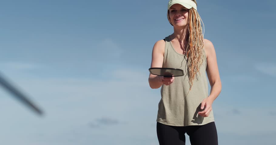 woman playing pickleball game, hitting pickleball yellow ball with paddle, outdoor sport leisure activity.