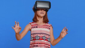 Young cute girl in VR glasses using headset helmet app to play simulation game. Watching virtual reality 3D 360 video. Preteen female child kid isolated on studio blue background. Little children - Powered by Shutterstock - Get 15% off with code: PIKWIZARD15