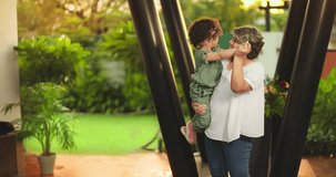 Happy Indian old grandmother holding cute little child girl in arms hands whirl dancing together outdoor home. Beautiful smiling woman sing song spinning small kid daughter enjoying summer holiday - Powered by Shutterstock - Get 15% off with code: PIKWIZARD15