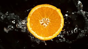 Super Slow Motion of Orange Slice With Water Splashes. Rotating Slice of Orange with Splashing Water Around. Isolated on Black Background. Filmed on High Speed Cinema Camera, 1000 Fps. Speed Ramp. - Powered by Shutterstock - Get 15% off with code: PIKWIZARD15