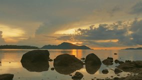 
amazing sky in sunrise above the rocks by the sea. 
clouds moving in yellow sky of sunrise at Rawai beach Phuket. 
stunning golden sky reflection of sunrise in sea surface.
gradient color background