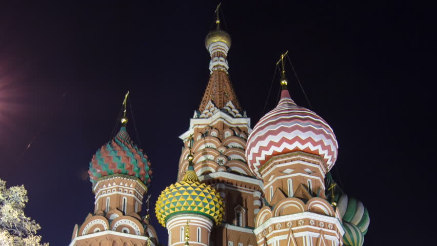 Back side of St. Basils cathedral with colorful domes illuminated at night from Red Square timelapse hyperlapse in Moscow, Russia