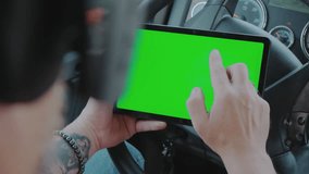 The driver in the truck holds a tablet with a green screen in his hands. Close up - Powered by Shutterstock - Get 15% off with code: PIKWIZARD15