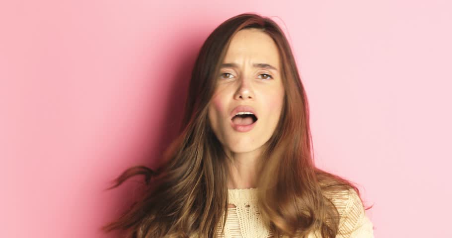 Charismatic young woman  angrily calls someone, with her finger forward and a gesture of coming and is ready to rag isolated over pink background. Hey you, come to me! Royalty-Free Stock Footage #1106667849