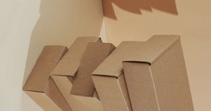 Vertical video of stacked cardboard boxes with copy space over brown background. Cyber monday, black friday, online shopping, shipping and global connections concept.