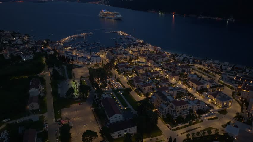 Montenegro Porto Novi marina at night establishing shot, aerial view. evening illumination. cruise ship on the sea - kotor bay. Crane shot. Royalty-Free Stock Footage #1106670433
