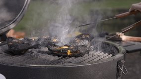 A 4k video of chicken grilling on a barbecue and being flipped. 