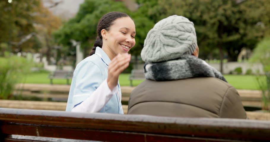 Nurse, happy and support with old woman on park bench for retirement, elderly care and conversation. Trust, medical and healthcare with senior patient and caregiver in nature, talking in a garden