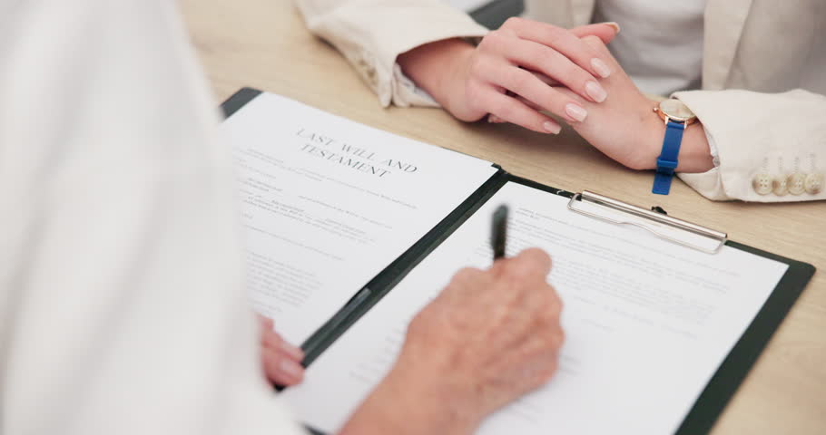 Document, signature and hands of a lawyer with a client for a will, planning death or agreement. Office, attorney and a legal employee writing on paperwork for a person in a law negotiation together