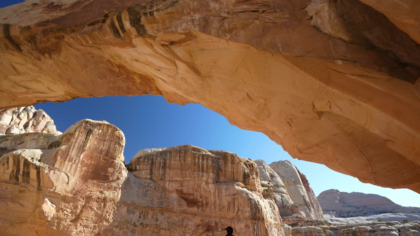 Capitol Reef National Park, Utah USA. Back of Person Standing on Rock Under Hickman Bridge, Natural Arch