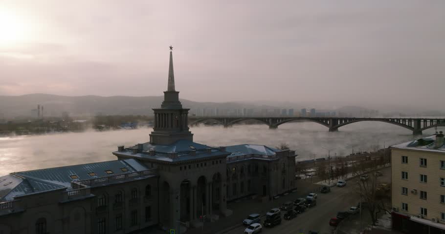 Aerial view of Krasnoyarsk river station, Yenisei river, communal bridge, copter flying over the station POV, winter, fog over the river Royalty-Free Stock Footage #1106687197