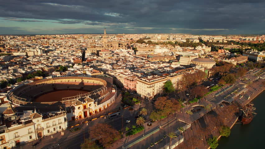 Flighting over the Seville city center at sunset, Spain. Aerial view of the Seville cityscape with corrida arena, Cathedral and Guadalquivir riverfront. Andalusia capital in summer