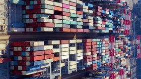Aerial view of business logistic import and export freight transportation by container ship. Cargo shipping container. Container ship unloading and loading in Container terminal. Vertical video