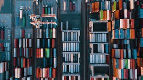 Drone view of shipping containers in a busy port. Logistics, transportation and shipment shot from above. 
Many containers moored in port. Aerial vertical, vertical video background.