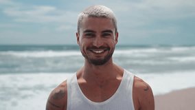 Portrait of One Young Man Looking at Camera on Water Waves Background. Beautiful Eyes and Happy Face of Smiling Male Person Standing at Sunny Outdoors. Optimism of Successful Adult Boy at Sun Beach 4k - Powered by Shutterstock - Get 15% off with code: PIKWIZARD15