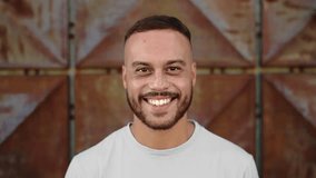 Portrait of Young Man Looking at Camera on Building Wall Background. Smiling Face and Beautiful Eyes of Happy Male Person Outdoors. Optimism of Successful Boy Standing at Architecture of City Street - Powered by Shutterstock - Get 15% off with code: PIKWIZARD15