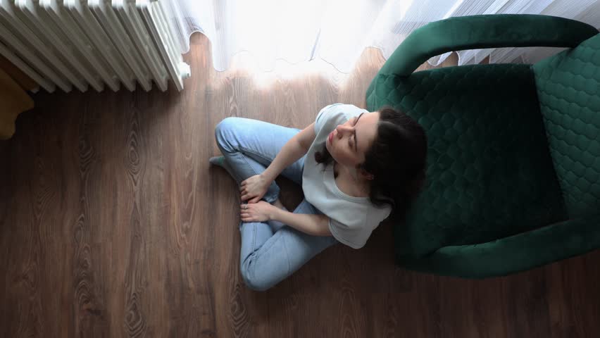 Psychology. Above view of anxiety woman is sitting near chair on floor in room and itching. Concept of loneliness and stress Royalty-Free Stock Footage #1106692907