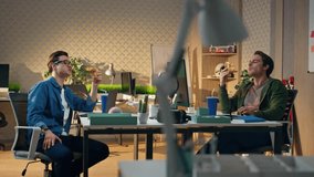 Relaxed guys enjoying lunch together at office break. Two male colleagues eating pizza telling funny life stories. Friendly business team tasting fastfood gathered at work room. Corporate lifestyle - Powered by Shutterstock - Get 15% off with code: PIKWIZARD15